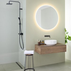 Ein modernes Badezimmer mit einer eleganten Dusche, einem runden Spiegel und einer stilvollen Holzwaschbeckenablage.