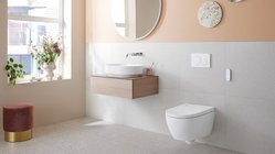 Ein modernes Badezimmer mit einer eleganten Wandspiegel und einem schlichten Waschbecken auf einem Holzregal.