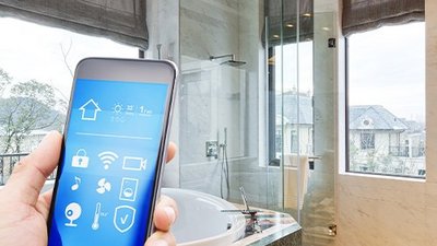 Badezimmer mit einer Hand die ein Smartphone hält, die eine Steuerung einer Lueftung-Klima-App zeigt.