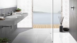 Ein modernes Badezimmer mit einem eleganten Waschbecken aus Beton und Blick auf einen ruhigen See durch große Fenster.